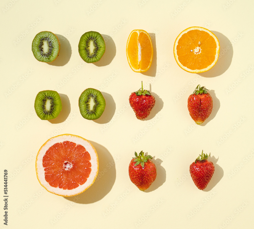 Fototapeta premium Food pattern made with fresh fruit slices on the yellow . background. Fruit healthy flat lay composition.