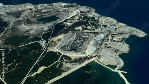 Aerial view of the island from an airplane. The Philippines. Mining quarries on an industrial island surrounded by a beautiful blue sea. 