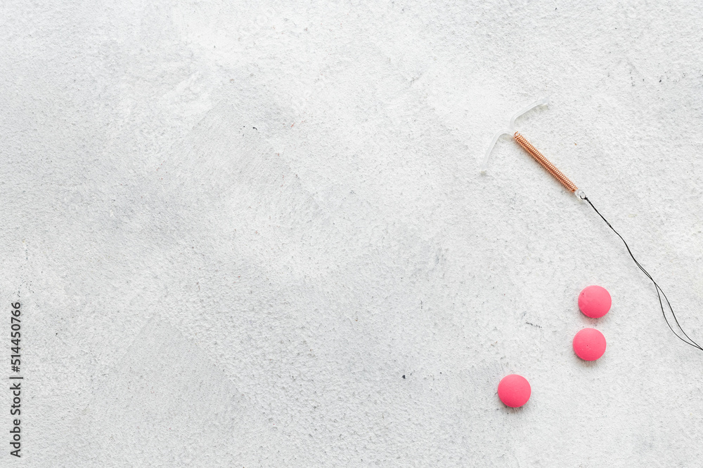 Contraception concept. T-shaped intrauterine contraceptive with medicine pills