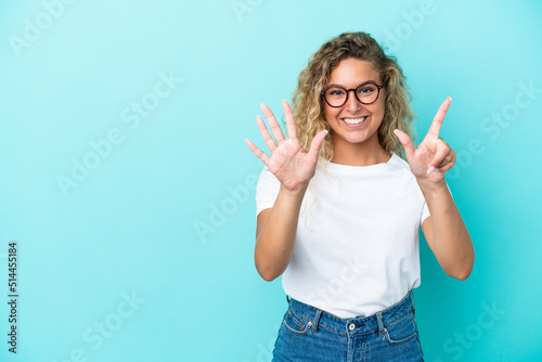 Girl with curly hair isolated on blue background counting seven with fingers