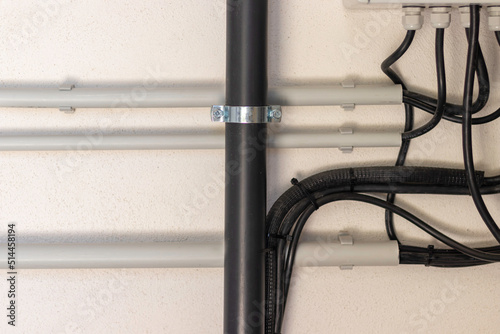 Close up view of electrical and plumbing instalation on white wall