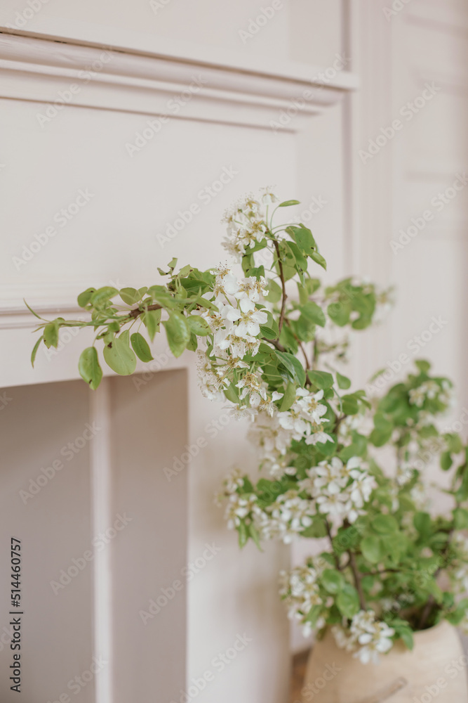 Flowering branches in a vase, fireplace. Minimalistic stylish interior. Flowering branches in a vase, fireplace. Minimalistic stylish interior.