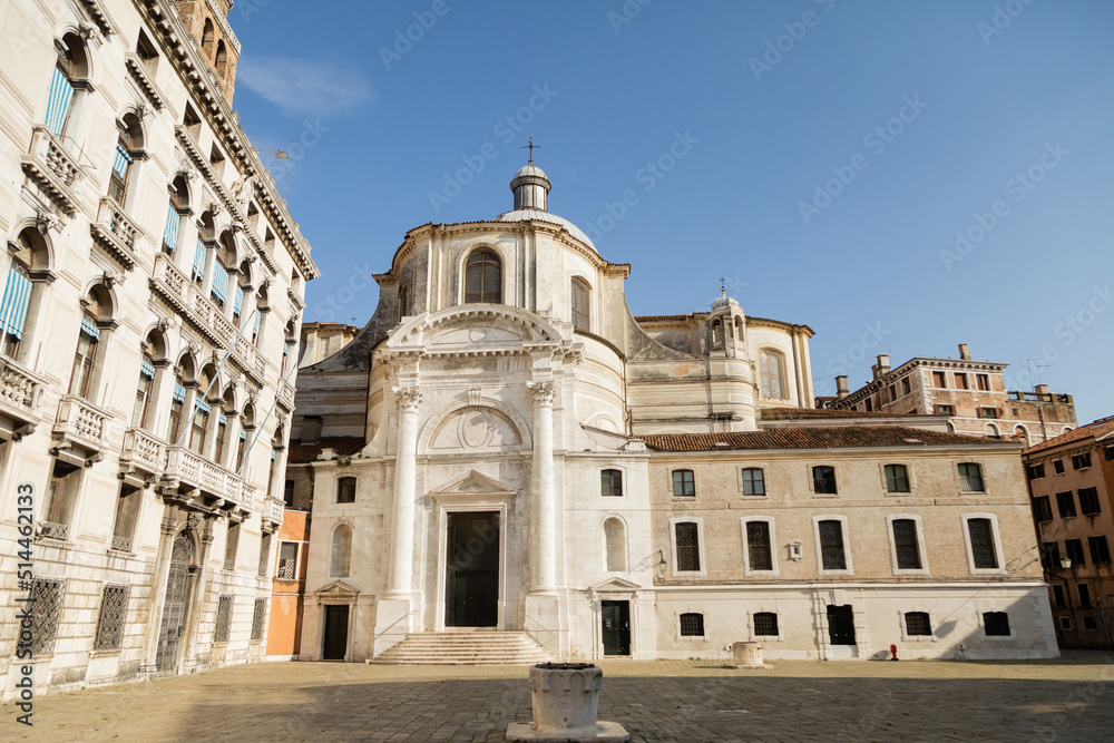 christian church and stone buildings on medieval square in Venice.