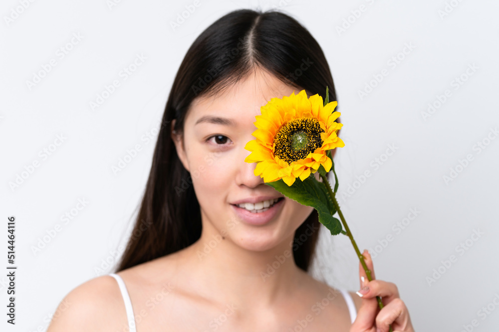 Young Chinese woman isolated on white background holding a sunflower while smiling. Close up portrait Young Chinese woman isolated on white background holding a sunflower while smiling. Close up portrait