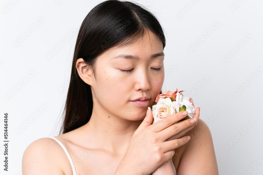 Young Chinese woman isolated on white background holding flowers. Close up portrait Young Chinese woman isolated on white background holding flowers. Close up portrait