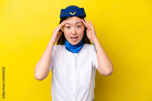 Airplane Chinese woman stewardess isolated on yellow background with surprise expression