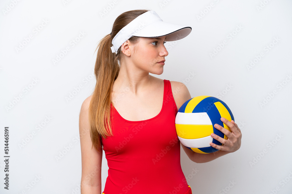Young caucasian woman playing volleyball isolated on white background looking to the side