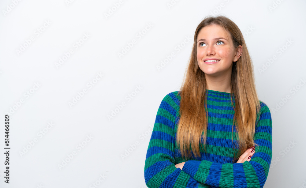 Young caucasian woman isolated on white background looking up while smiling
