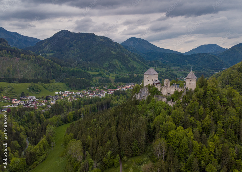 Aerial drone view of castle Gallenstein, close to Sankt Gallen in Austria on a cloudy summer day. Green forest surrounding the ruins of a castle.