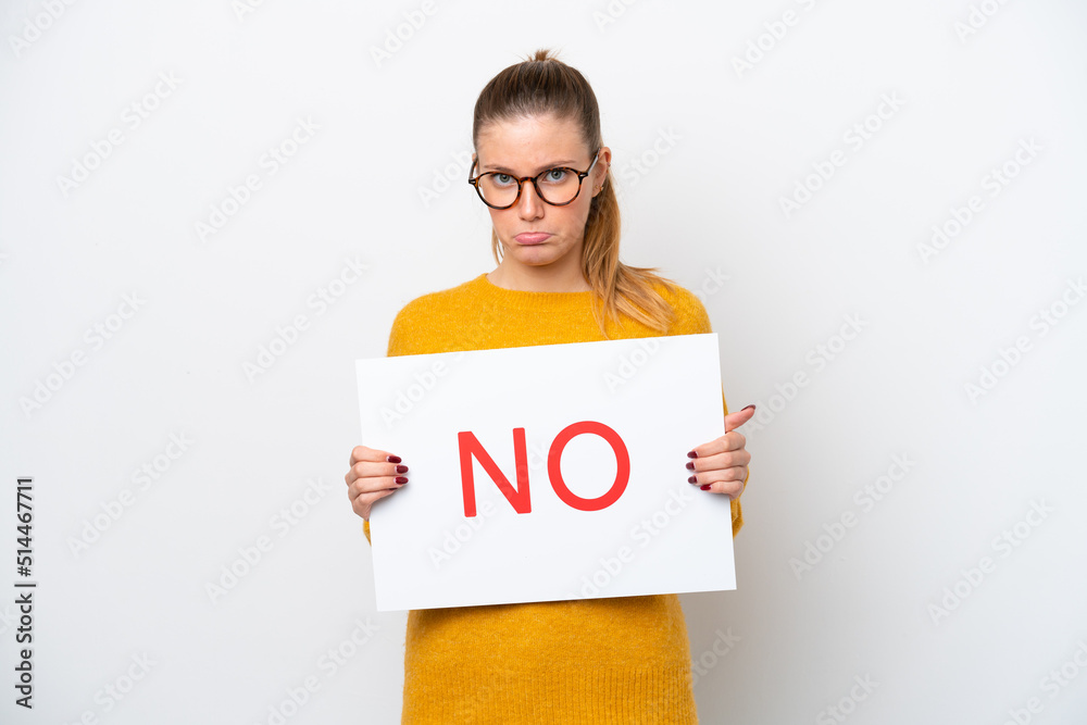 Young caucasian woman isolated on white background holding a placard with text NO with sad expression Young caucasian woman isolated on white background holding a placard with text NO with sad expression