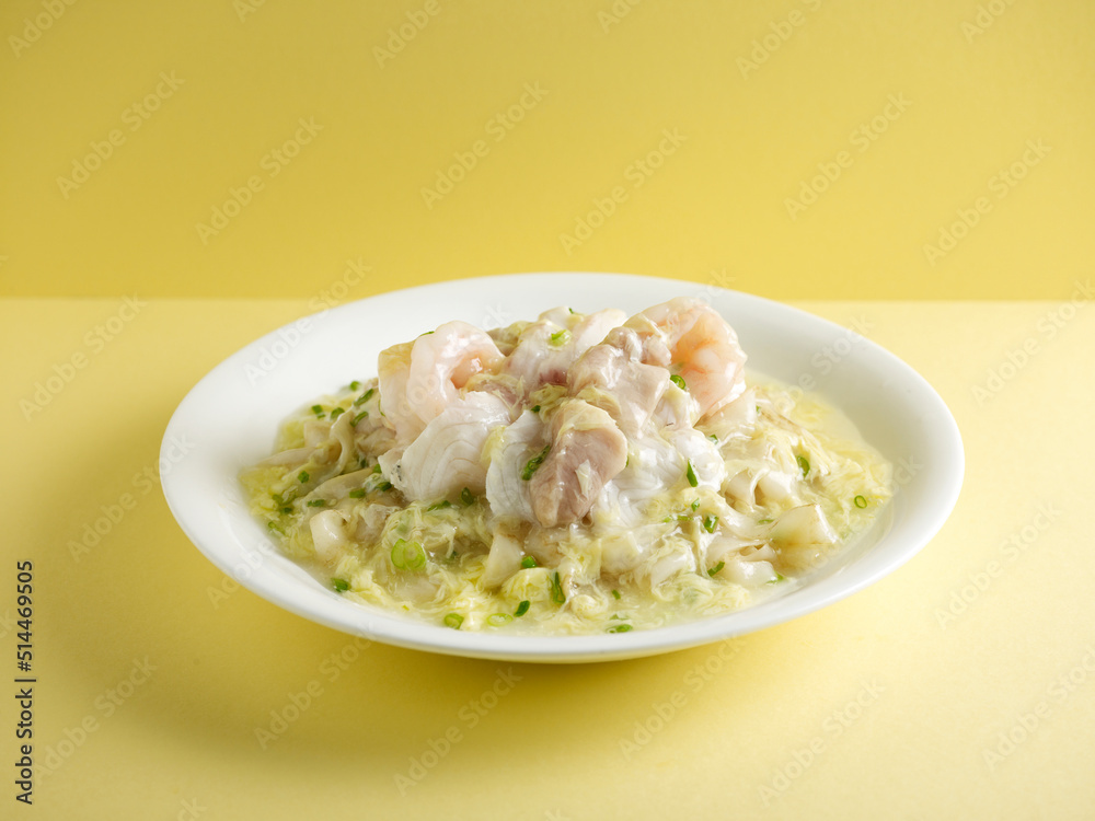 braised hor fun with seafood and scrambled egg with chopsticks served in a dish isolated on mat side view on grey background braised hor fun with seafood and scrambled egg with chopsticks served in a dish isolated on mat side view on grey background