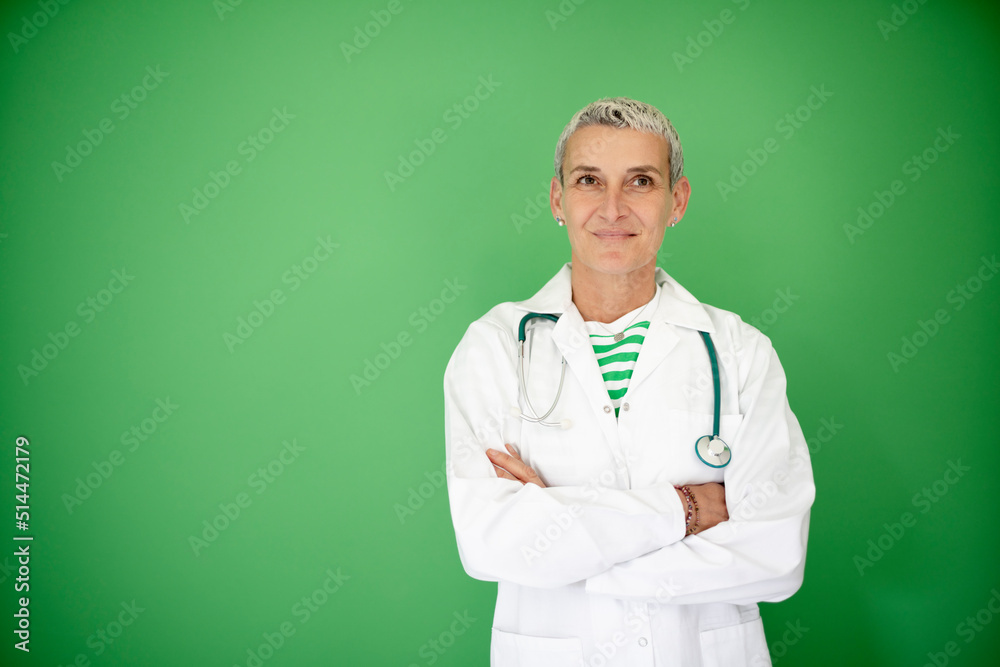 successful middle aged alternative woman doctor with short hair wearing white coat and stethoscope posing on green background successful middle aged alternative woman doctor with short hair wearing white coat and stethoscope posing on green background