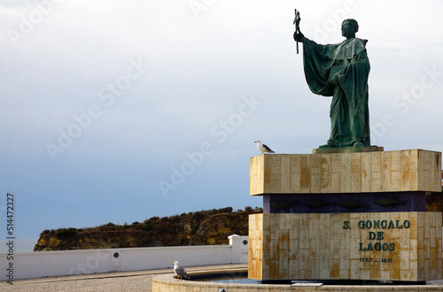 Europe, Portugal, Algarve region , Faro district , Lagos, bronze statue Sao Gonçalo de Lagos (Gundisalvus) - patron of the city in central viewpoint overlooking Atlantic Ocean photo