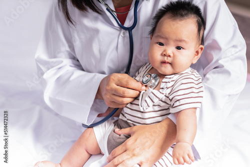 Woman doctor using a stethoscope, checking the respiratory system and heartbeat Of a 3-months-old baby newborn, to baby newborn and  health care concept.