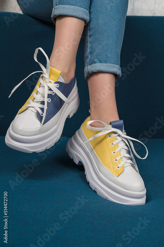 White sneakers with blue and yellow accents. Unisex sneakers