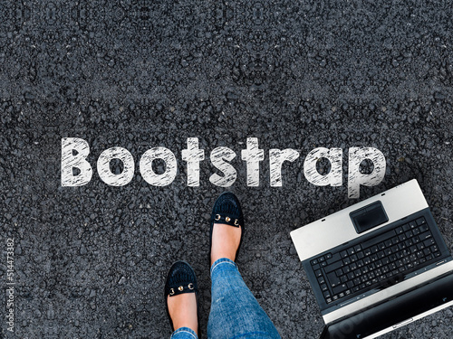 Bootstrap CSS framework . .A woman steps to a laptop and Bootstrap word on asphalt road
 photo