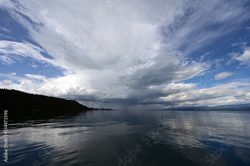 Beautiful dramatic summer cloudscape over Flathead Lake in Montana on calm June day.