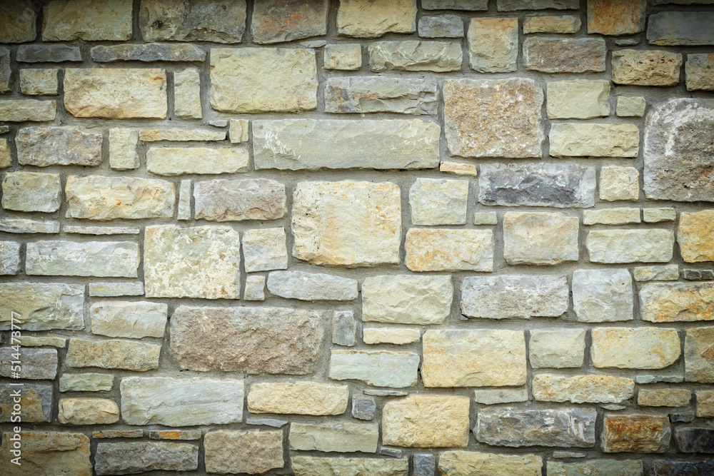 Solid yellow and beige stone wall with vignette, good for background Solid yellow and beige stone wall with vignette, good for background