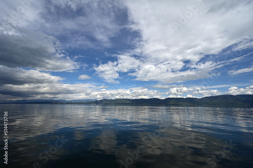 Beautiful dramatic summer cloudscape over Flathead Lake in Montana on calm June day.