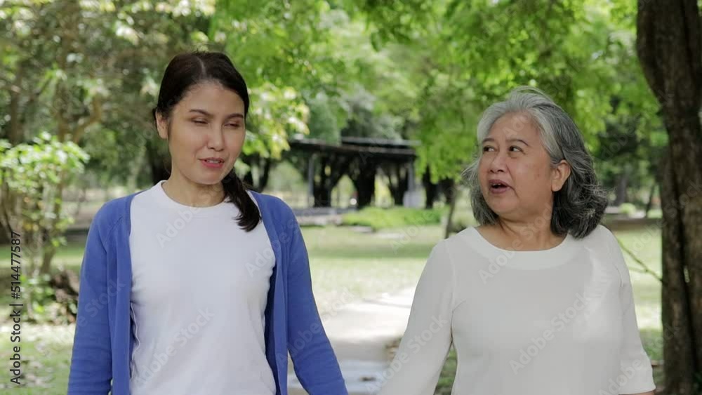 Elderly mother with happy Asian daughter smiling Take a walk and exercise in the park. family concept Healthcare. Elderly caregive Elderly mother with happy Asian daughter smiling Take a walk and exercise in the park. family concept Healthcare. Elderly caregive