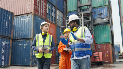 Container terminal employees walking and checking container cargo in warehouse