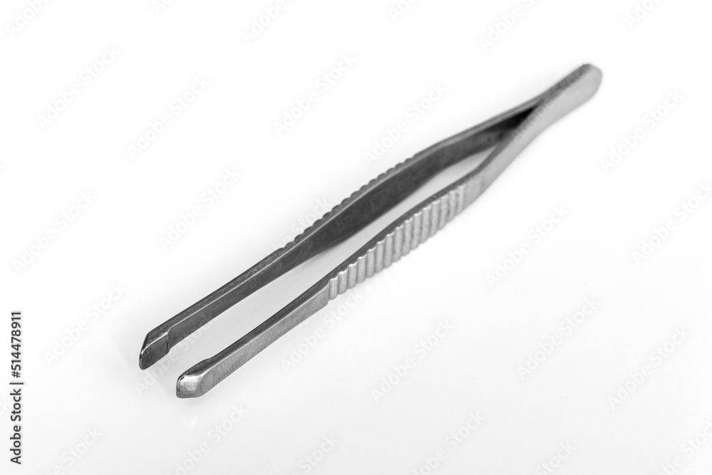 Close-up of metal tweezers on a blurred white background. Anatomical forceps, health and beauty accessories concept Close-up of metal tweezers on a blurred white background. Anatomical forceps, health and beauty accessories concept