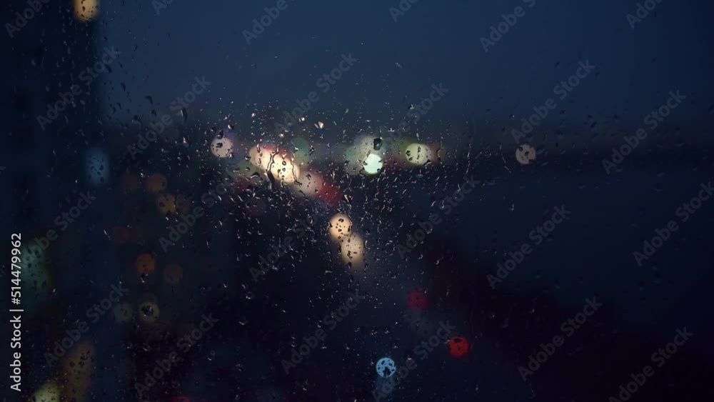 Bokeh of city lights and flashes of lightning through raindrops on the window. Bokeh of city lights and flashes of lightning through raindrops on the window.