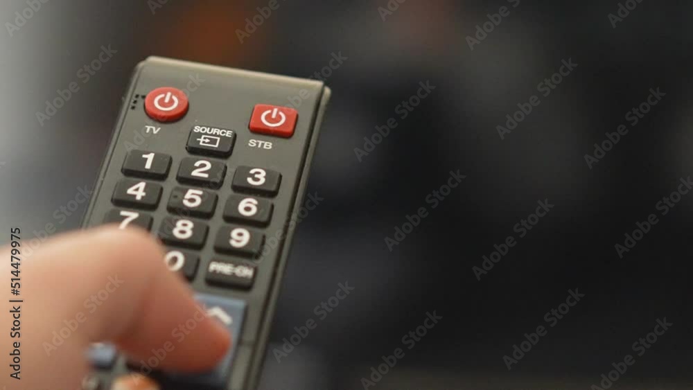 Changing channels on television with remote control extreme close-up shot Changing channels on television with remote control extreme close-up shot