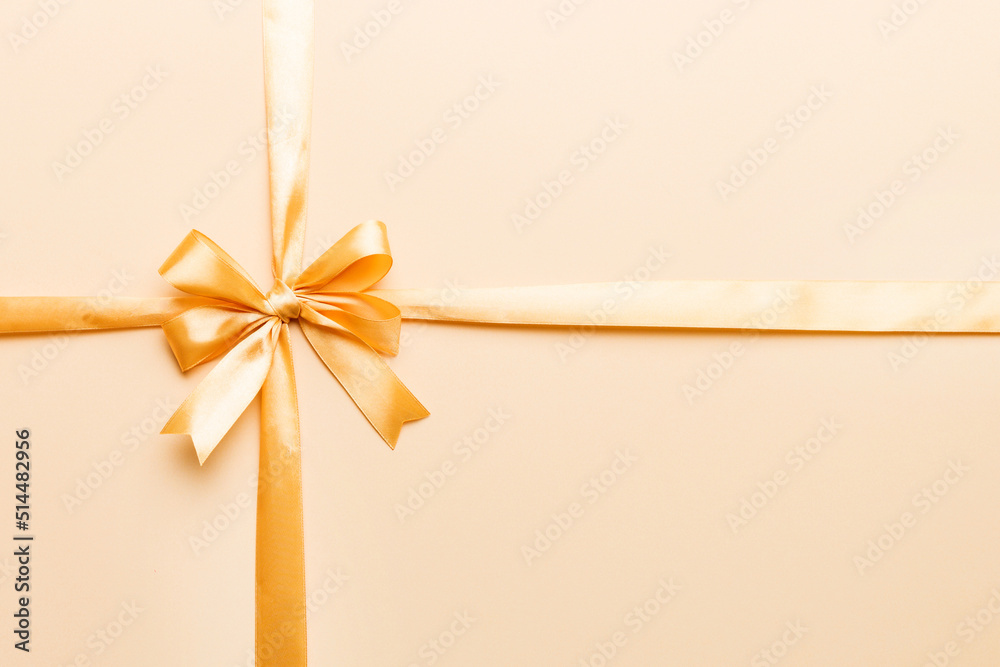 Top view of gold ribbon rolled and yellowbow isolated on colored background. Flat lay with copy space Top view of gold ribbon rolled and yellowbow isolated on colored background. Flat lay with copy space