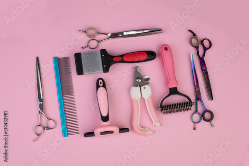 Tool for the groomer on a pink background. Dog grooming accessories. Combs and brushes for animals. View from above