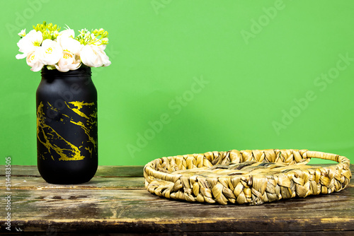 Empty Esparto halfah plate on wooden table with roses flowers pot. Kitchen mock up for design and product display photo