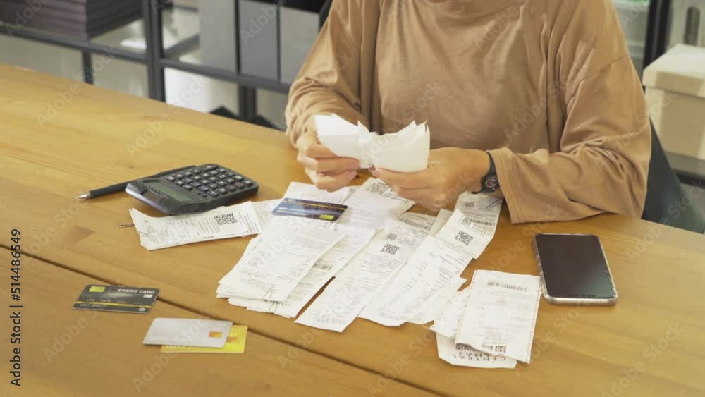 Portrait of stressed Asian woman, audit person and confused by calculate expense from invoice or receipt bills debt. No money to pay, mortgage or loan,bankruptcy at home.People lifestyle