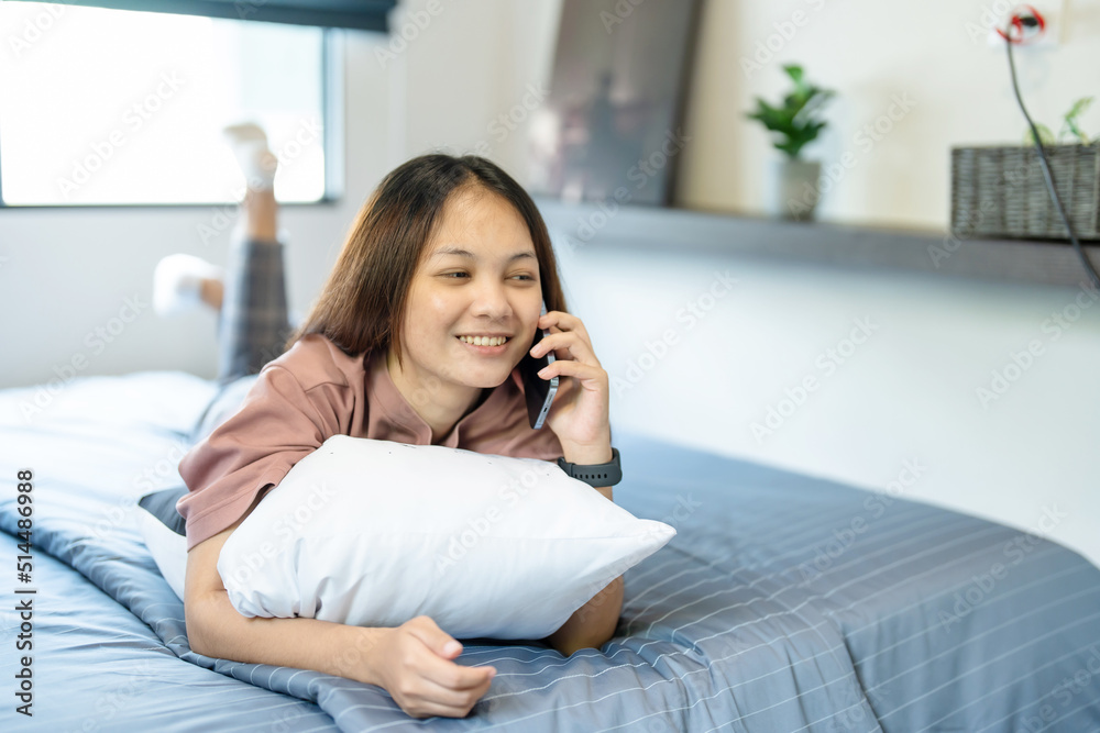 medium shot A teenage long-haired Asian woman lies on the bed in her bedroom. She had a phone in her hand and was chatting happily with her friends online. medium shot A teenage long-haired Asian woman lies on the bed in her bedroom. She had a phone in her hand and was chatting happily with her friends online.