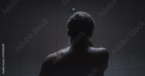 Young black male taking a shower and thinking. photo