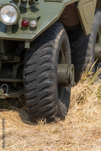 part of a photo of an armored car standing in the meadow behind other military vehicles