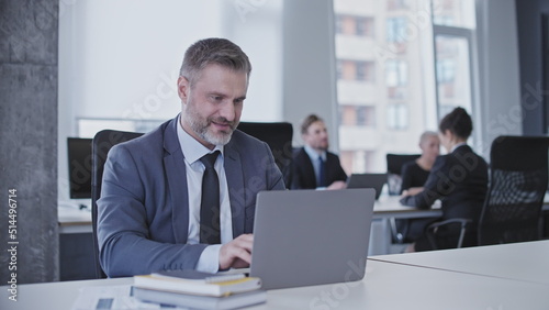 Businessman typing on laptop, focused on important project, office atmosphere