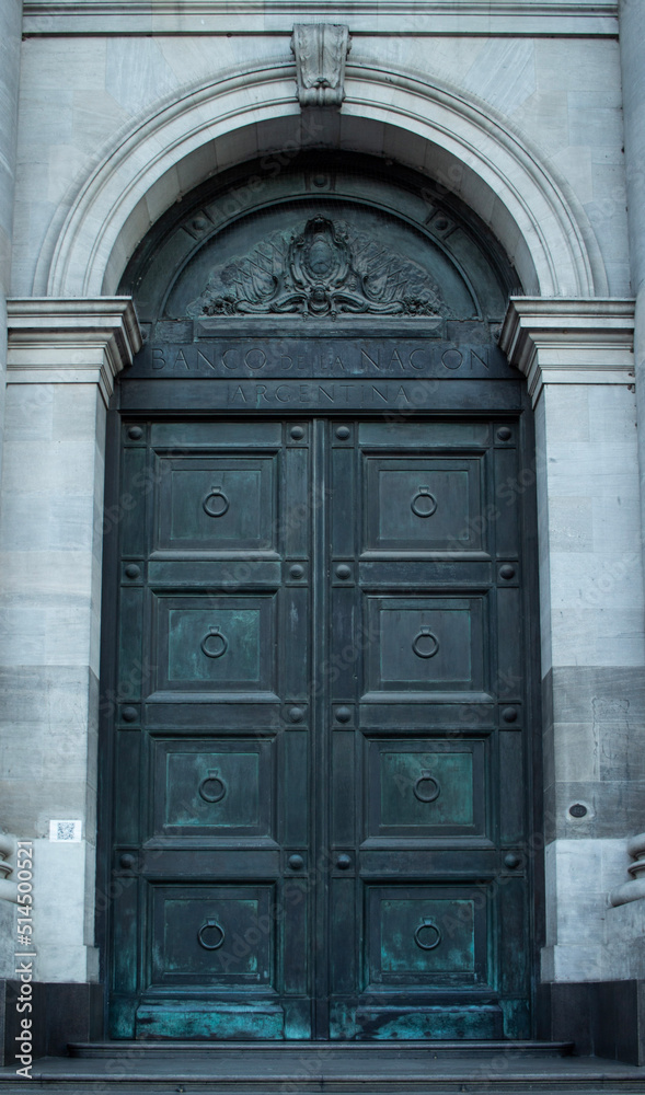 Heavy metalic double door outside of an old bank in buenos aires argentina. arch door frame.