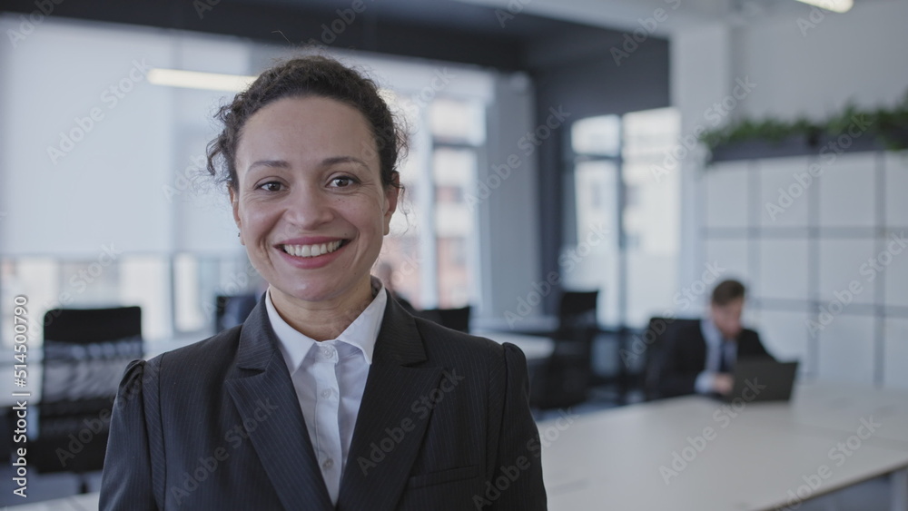 Excited woman office worker smiling on camera, happy to work in friendly atmosphere Excited woman office worker smiling on camera, happy to work in friendly atmosphere