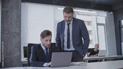 Slika na platnu Male boss supervising work of newbie office manager, giving advice, internship
