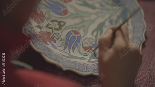 woman making handmade ornamental plates painting the plate in close-up