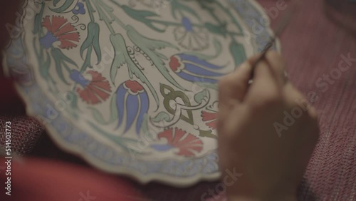 woman making handmade ornamental plates painting the plate in close-up