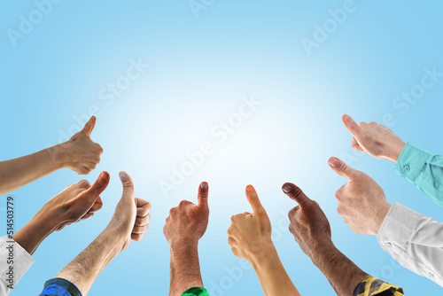 Hands with thumbs up. Concept of successful teamwork, or public approval. Like thumb ok symbol, yes, okay, good, well, fine, nicely photo