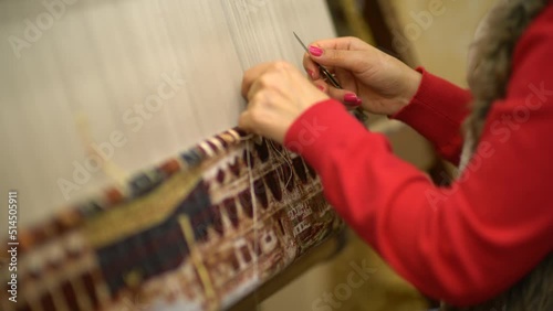 woman weaving a handmade carpet close-up
