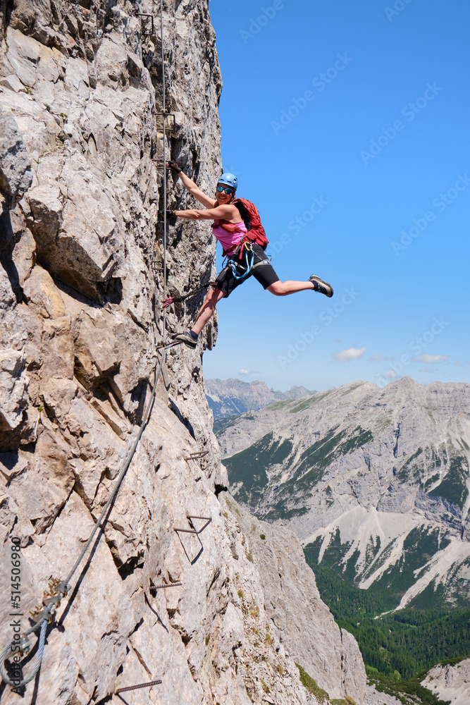Active woman on vertical via ferrata at Nordkette, Innsbruck, Austria. Rock details, adventure, activity, tourism, klettersteig.