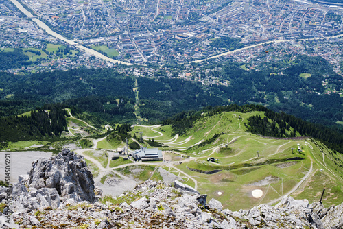 Innsbruck city from above Seegrube station of Nordkette cable car, with winding bike and hike trails. Top view.