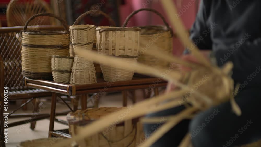 male worker weaving wicker baskets in the workshop where handmade wicker baskets are produced