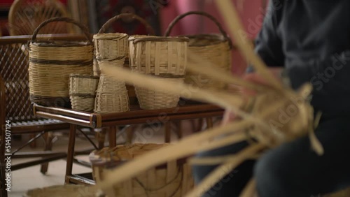 male worker weaving wicker baskets in the workshop where handmade wicker baskets are produced