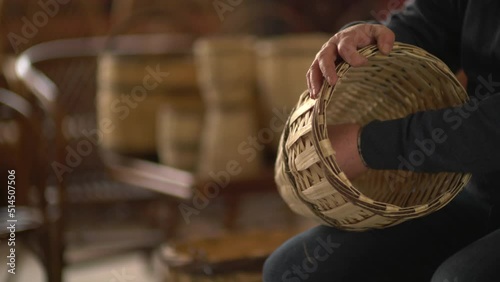 male worker weaving wicker baskets in the workshop where handmade wicker baskets are produced