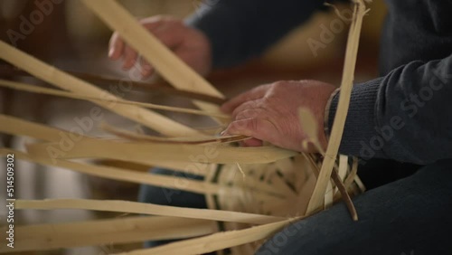 male worker weaving wicker baskets in the workshop where handmade wicker baskets are produced