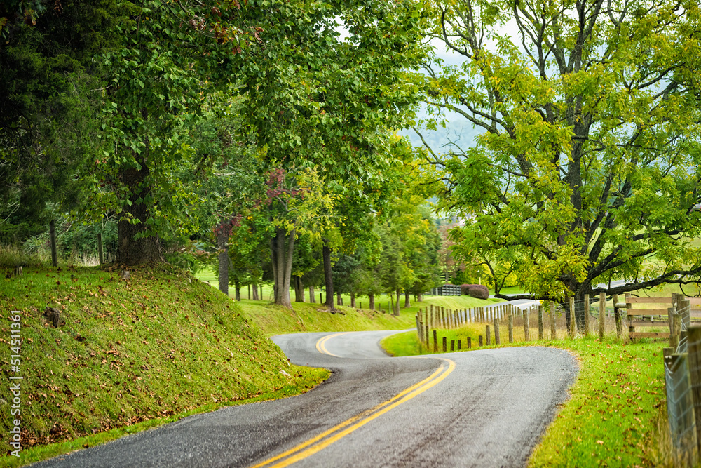 Buena Vista, Virginia small countryside rural town in USA in fall season with empty winding curvy road through farms and green trees with nobody